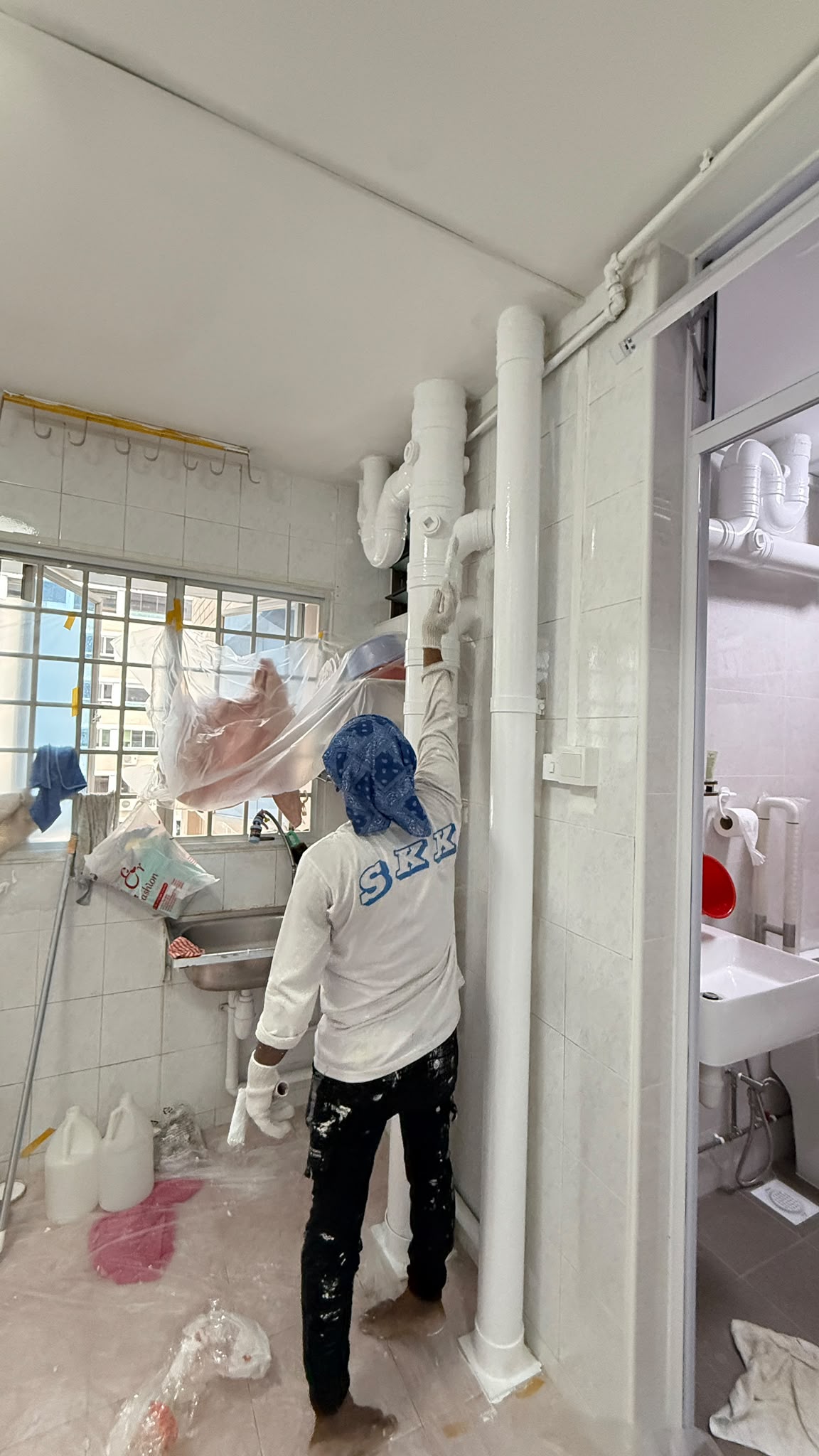 Kitchen and toilet pipe area after professional painting and surface finishing in Singapore